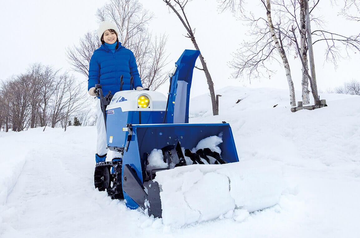 除雪機で女性が雪を集めている写真