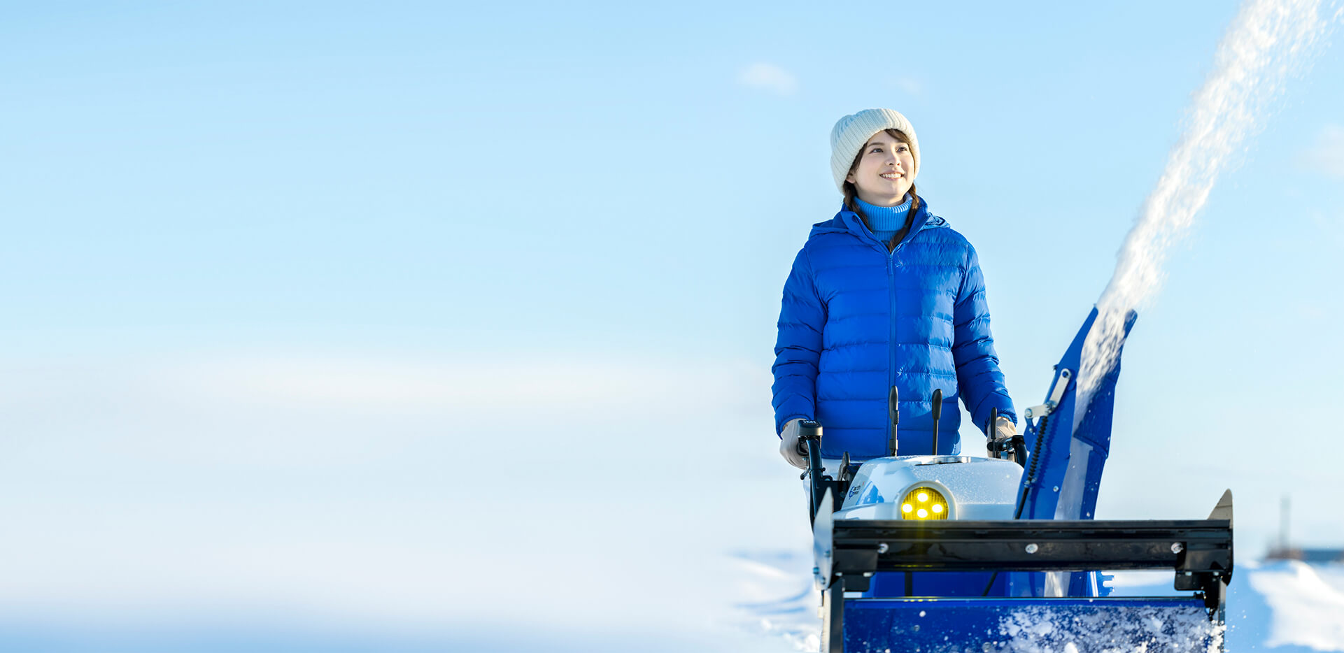 女性が除雪機を扱っている写真